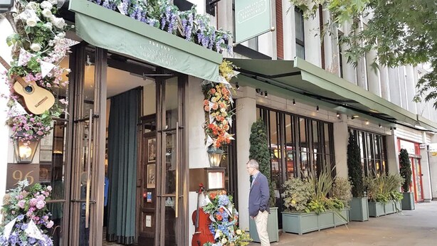 Un bâtiment doté d’une marquise verte et d’une enseigne indiquant : « The Ivy Kensington Brasserie ».