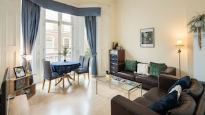Un salon comprenant un coin repas, un canapé, une table basse et une bibliothèque.