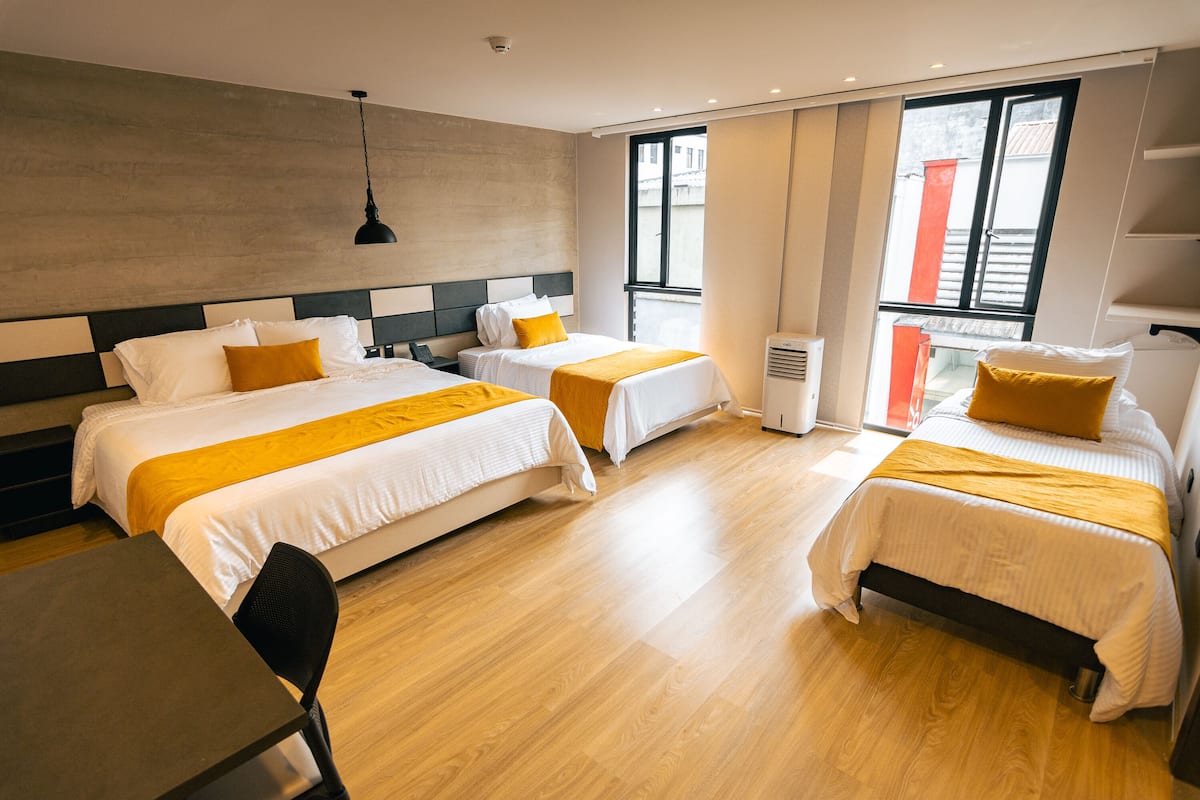 A hotel room with two beds, a desk, and a chair.