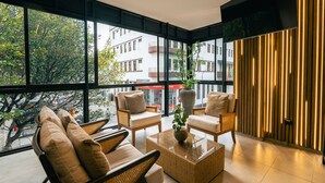 A modern lounge with large windows, wicker furniture, and a view of the cityscape. - Hotel Balmoral Plaza (Pereira)