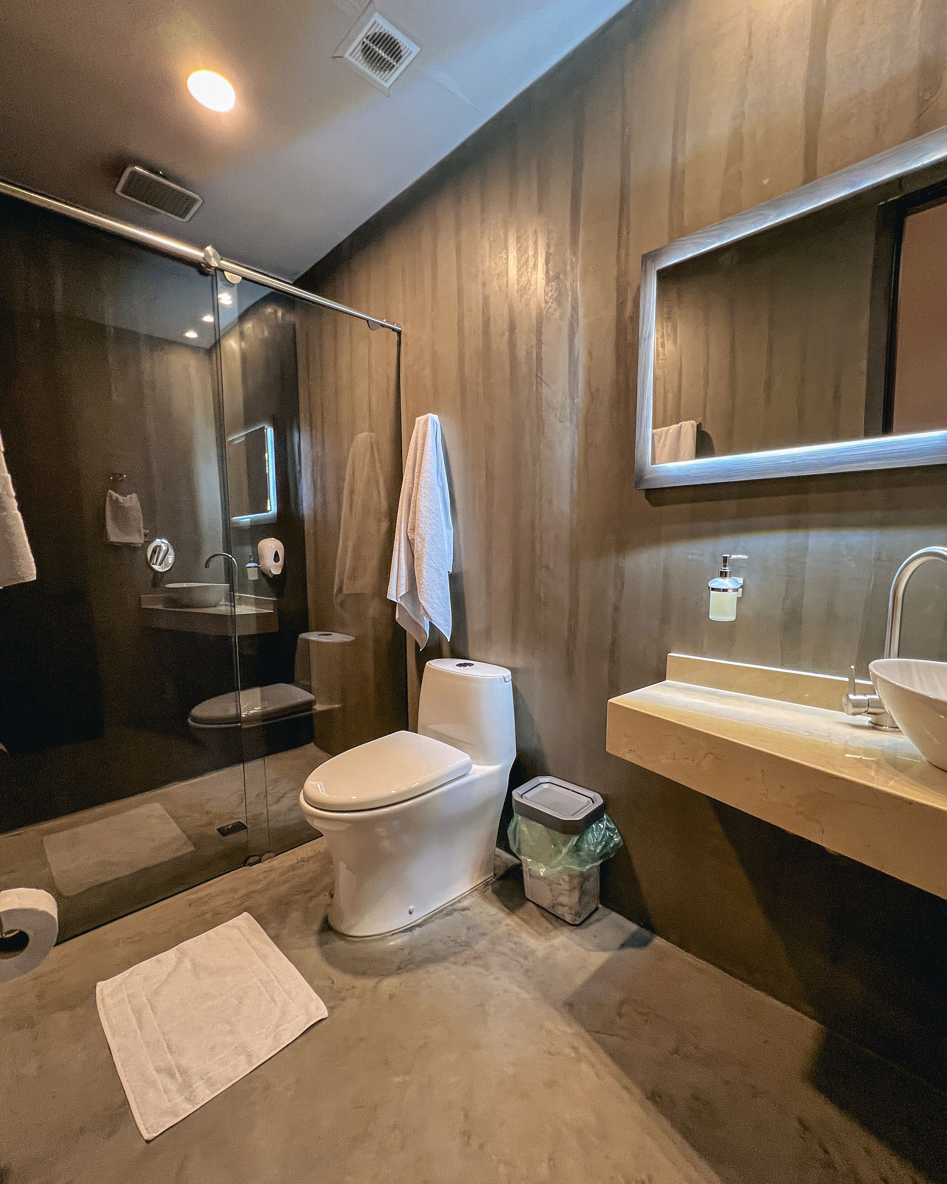A modern bathroom with a toilet, sink, and shower.