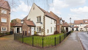 A residential area with houses, paved sidewalks, and a black metal fence. - Central Apartment in Cathedral City of Ripon (RIPON)