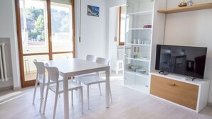 Eine moderne Küche mit Esstisch, Stühlen, Fernseher und einer Glaskabine.