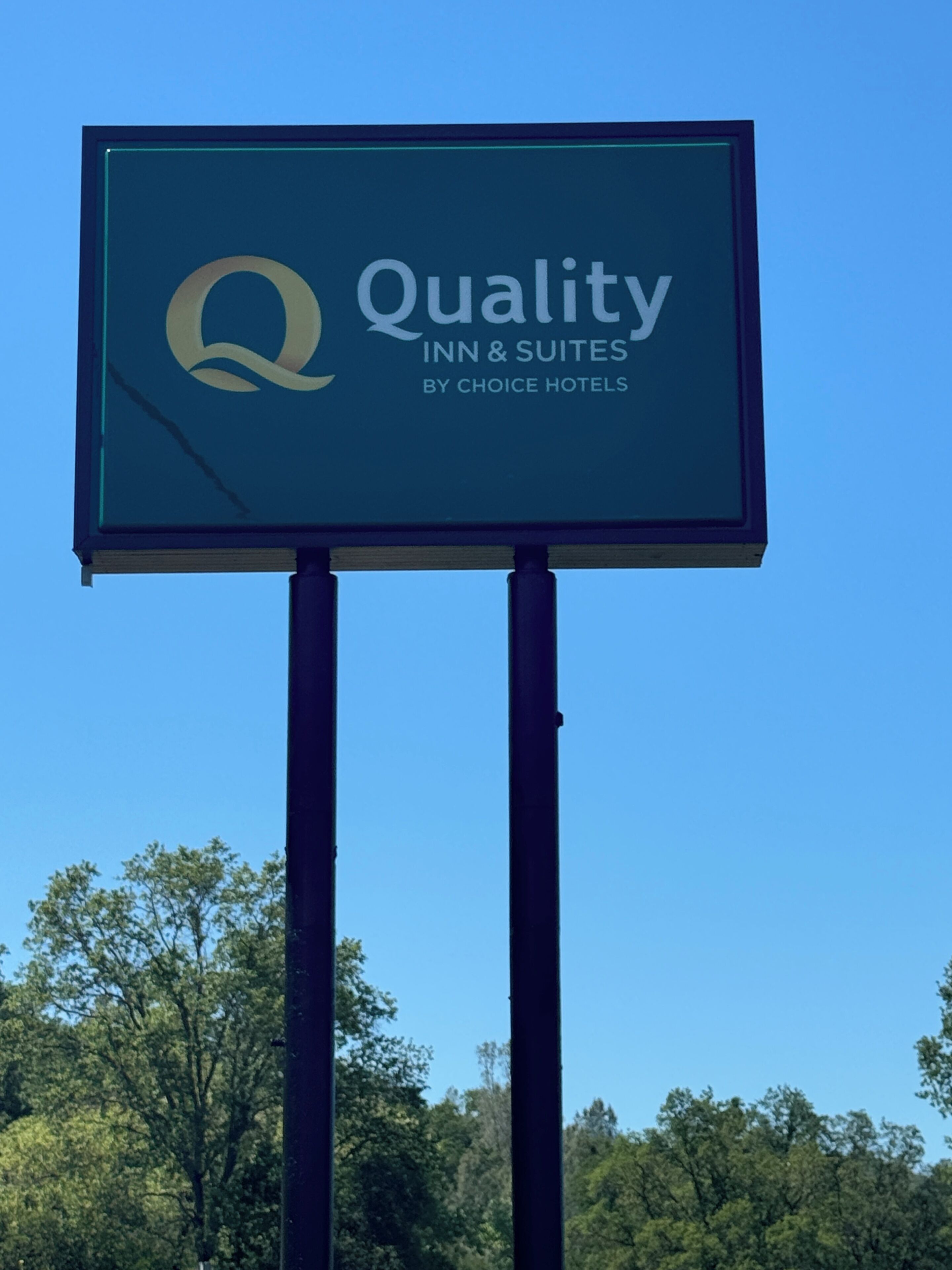 A sign for Quality Inn & Suites by Choice Hotels with a logo and text.