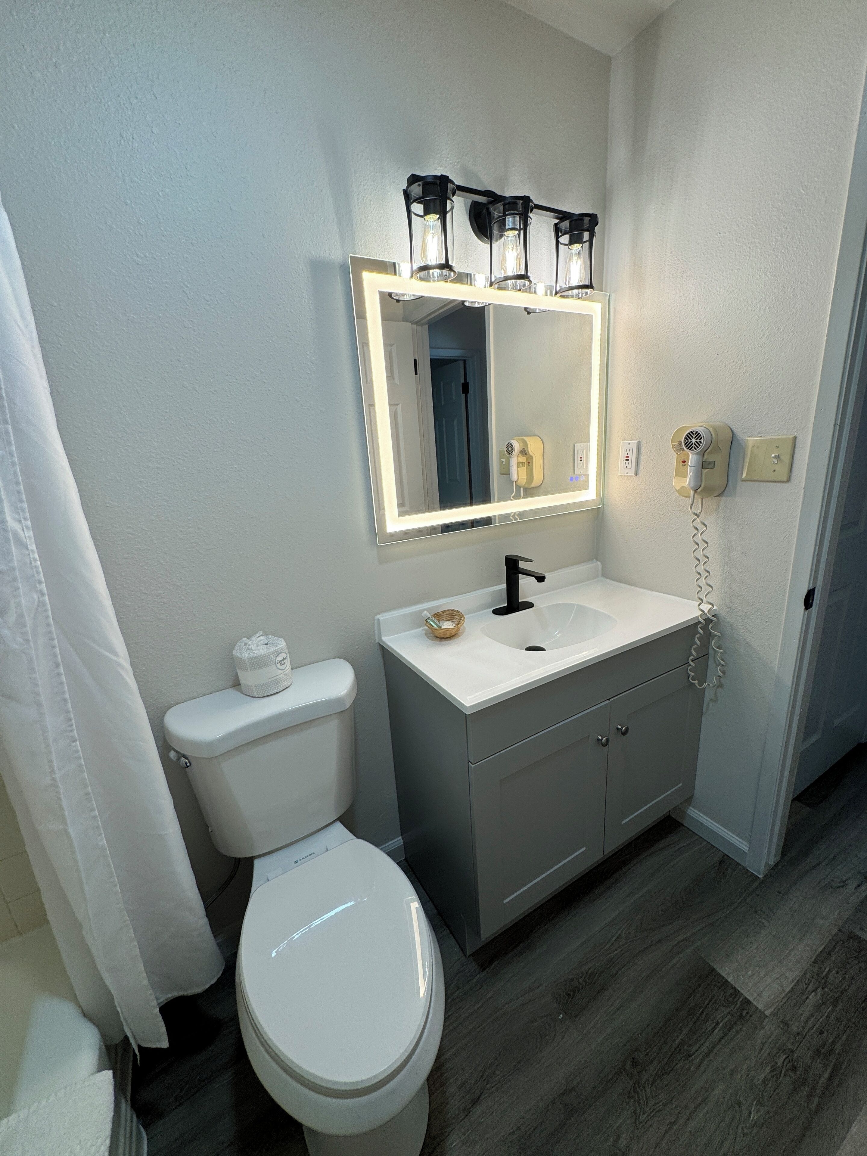 Un baño con inodoro, lavabo y espejo.