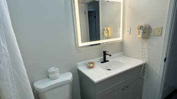 Un baño con inodoro, lavabo y espejo.