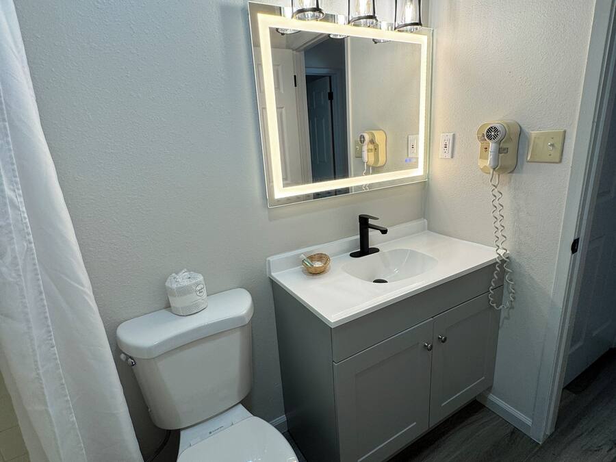 Un baño con inodoro, lavabo y espejo.