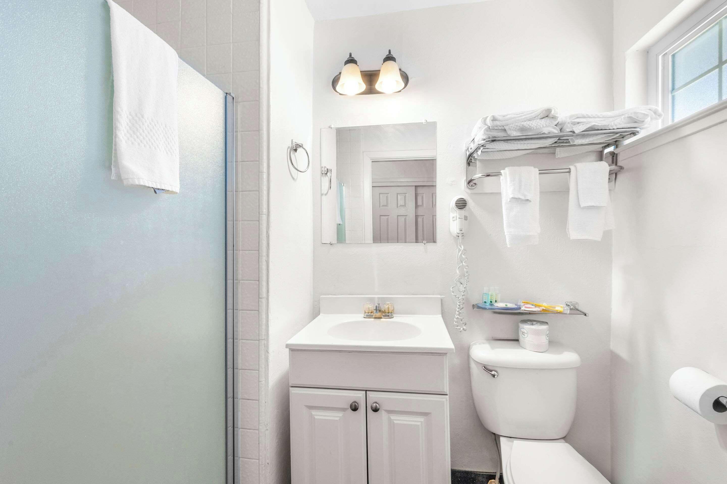 A bathroom with a white sink, toilet, and a towel rack.