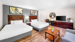 A hotel room with two beds, a TV, a desk, and a chair. - Quality Inn & Suites Jackson (Jackson)