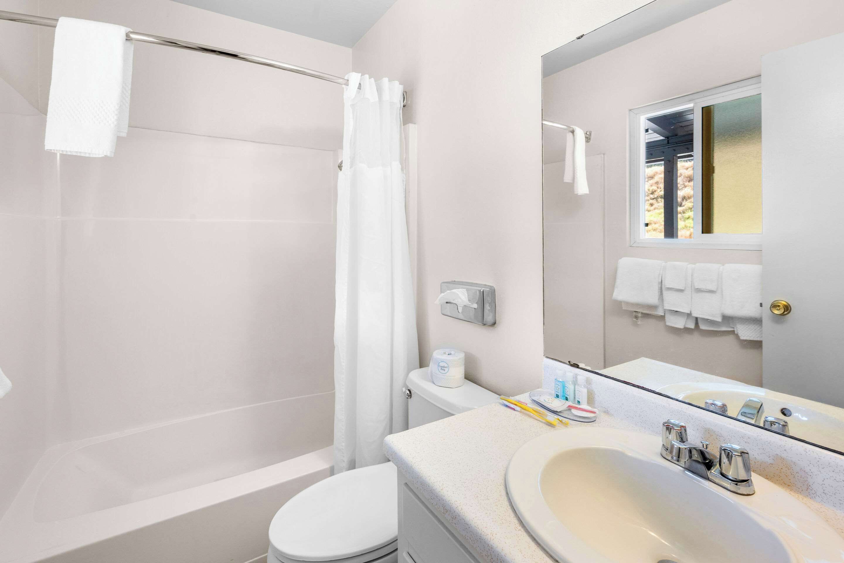 A bathroom with a bathtub, toilet, and sink.