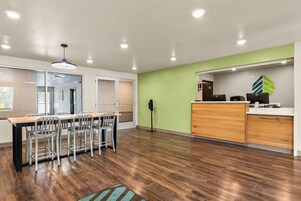 Una cocina moderna con armarios de madera, una encimera y una pared de acento verde.