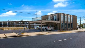 A modern building with a covered entrance and a parking area. - Econo Lodge Gretna - New Orleans (Gretna)