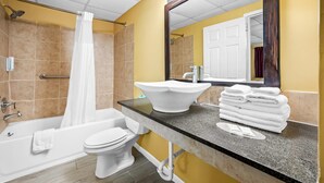 A bathroom with a bathtub, toilet, sink, and a mirror. - Econo Lodge Gretna - New Orleans (Gretna)