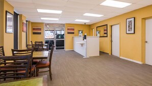 A hotel lobby with wooden flooring, a reception desk, and framed artwork on the walls. - Econo Lodge Gretna - New Orleans (Gretna)