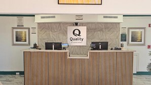 A hotel reception desk with a sign reading "Quality by Choice Hotels". - Quality Inn & Suites (Metairie)