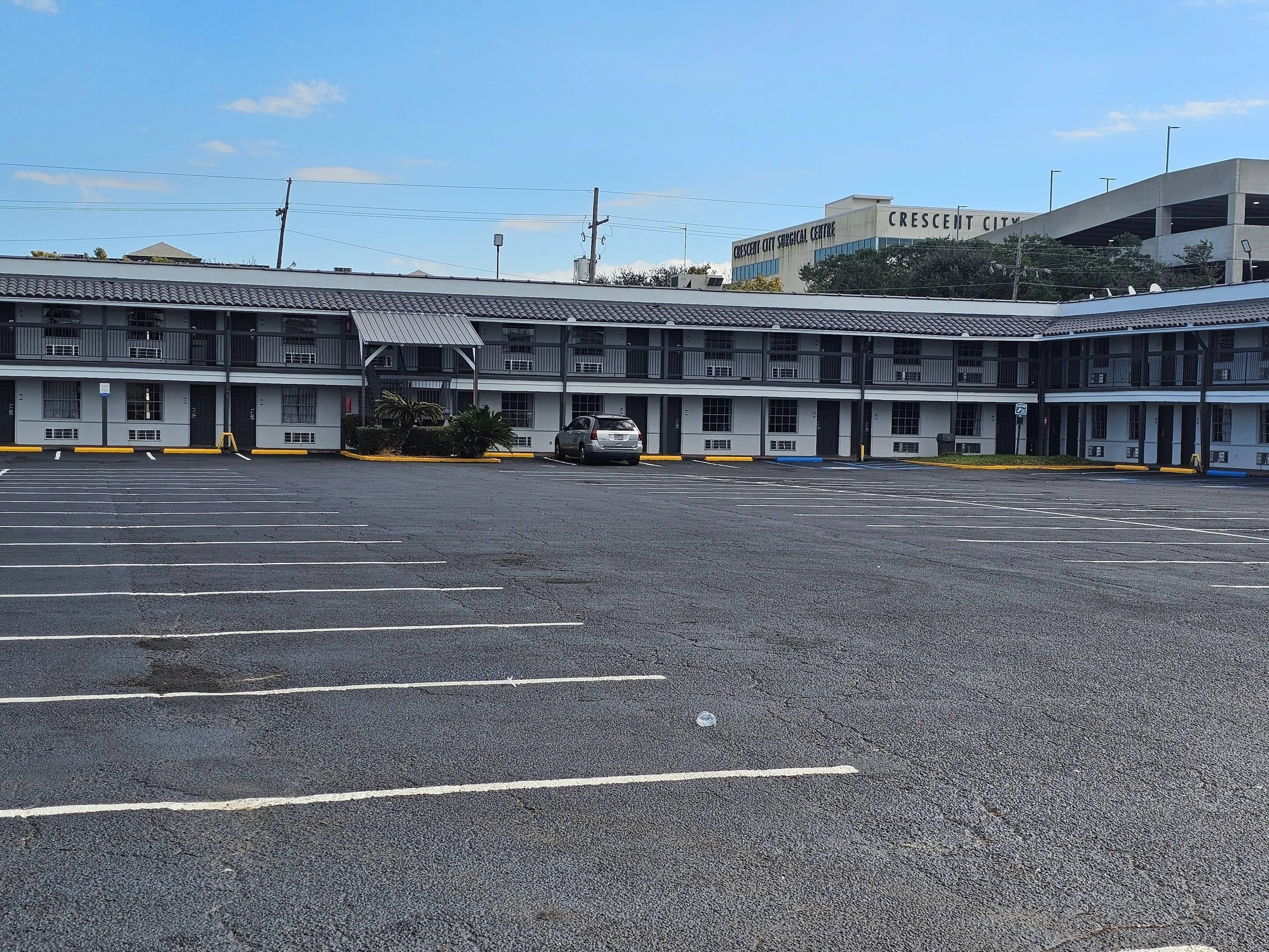 A multi-story parking garage with a flat roof and a building labeled 'Crescent City Surgical Centre' in the background.