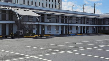 Et motel med parkeringsplads og en bygning med flere etager og balkoner.