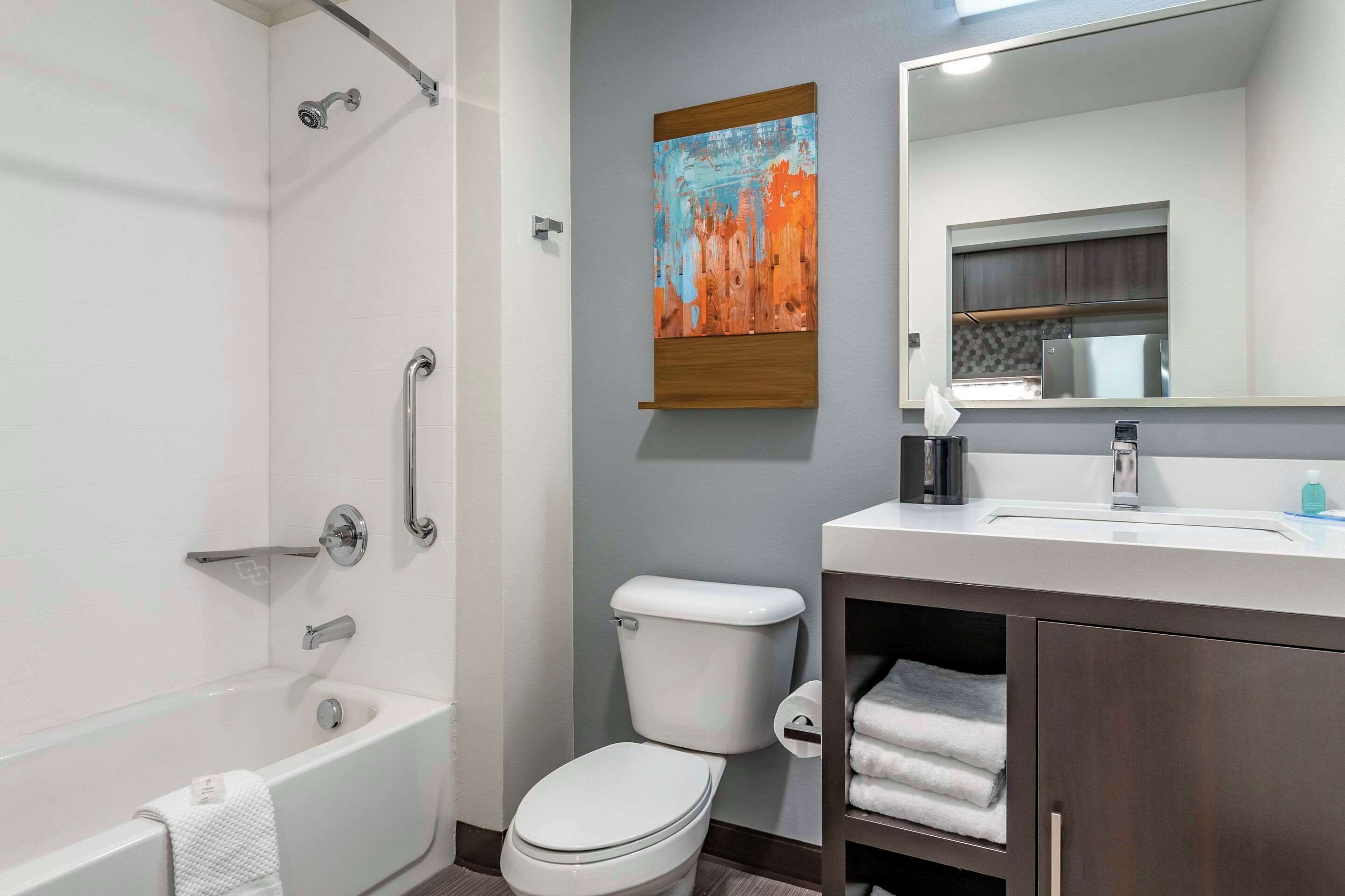 A modern bathroom with a bathtub, toilet, and sink.