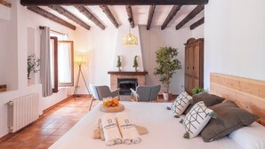 Un dormitorio acogedor con una cama grande, dos sillones, una chimenea y un cabecero de madera.