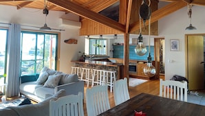 A spacious living area with a wooden ceiling, a dining table, and a sofa. - Beautiful Orford with Maria Island Views.
Pet Friendly and Loads of Space (Orford)