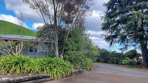 A building with a green roof, surrounded by various trees and plants. -  Captivating rural beauty, serene getaway, nestled midway  Rotorua & Taupo. (Rerewhakaaitu)