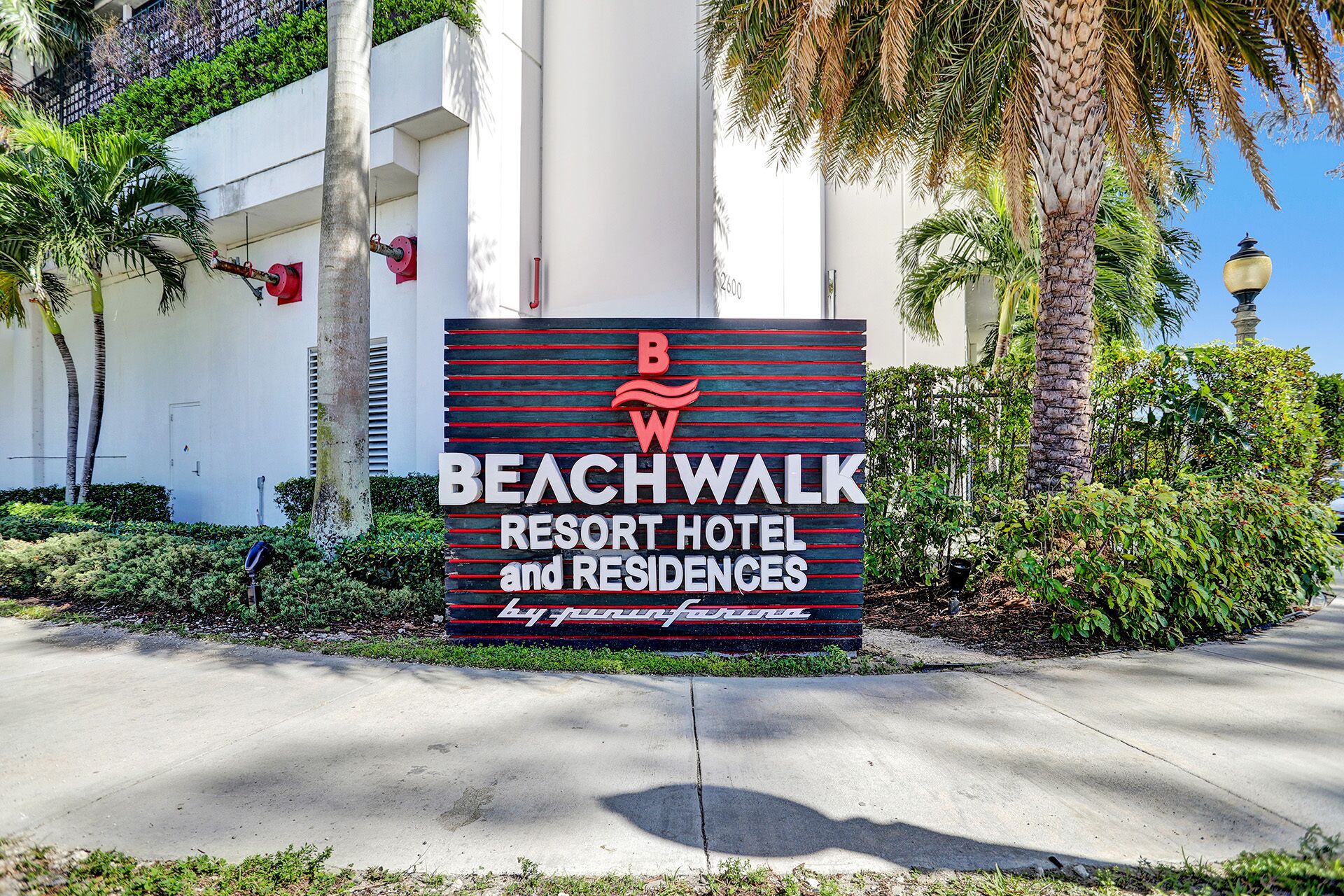 A sign for Beachwalk Resort Hotel and Residences with a logo and name.