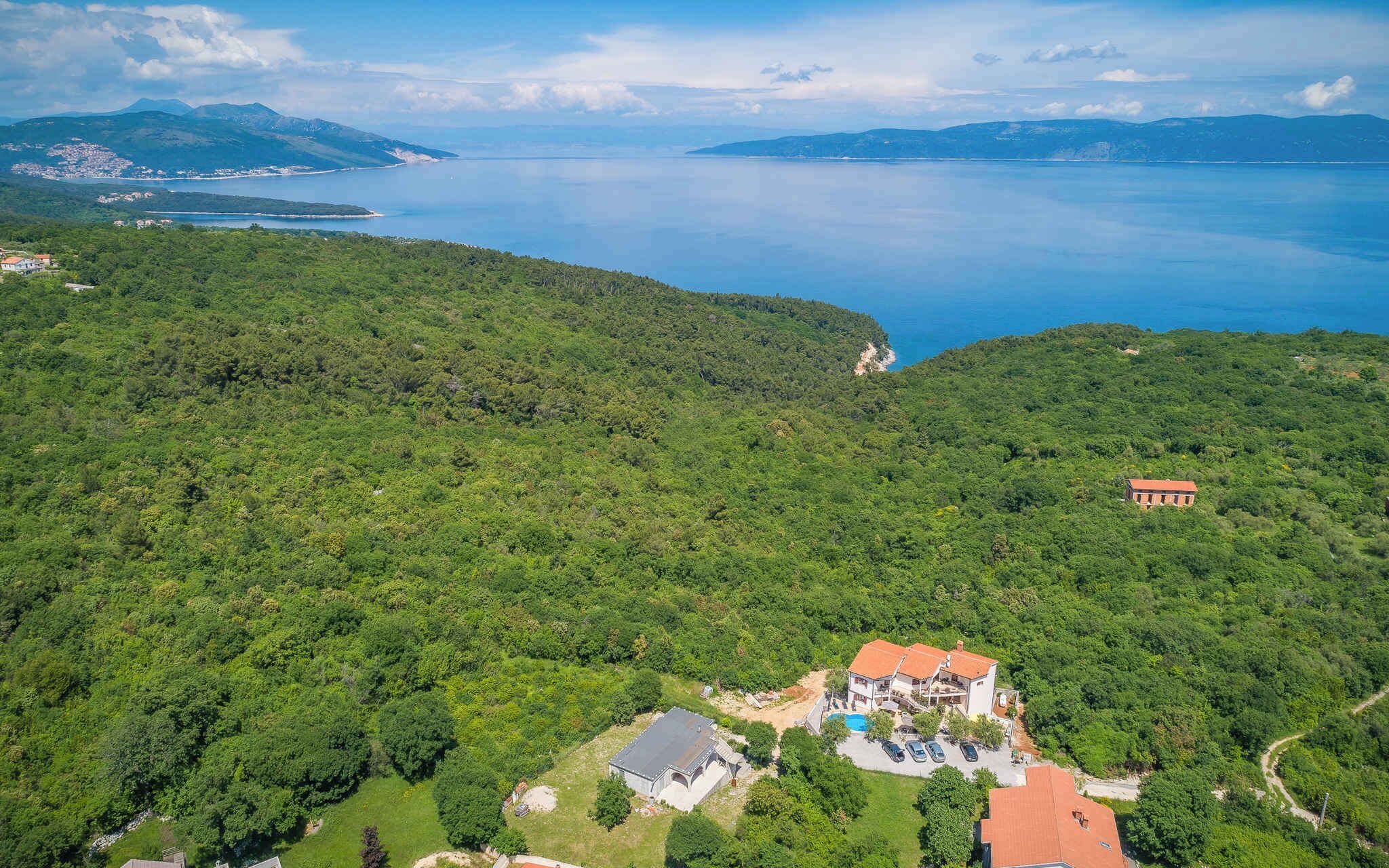 A large house with a swimming pool and a view of a lake.