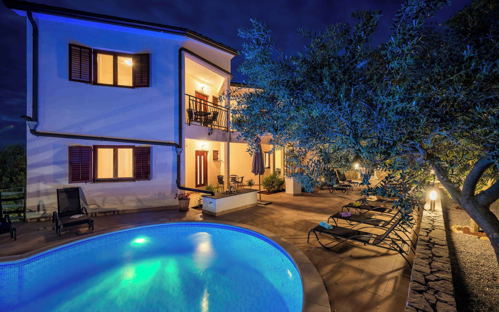 Un bâtiment à deux étages doté d’une piscine, d’un espace extérieur aménagé et d’un balcon bien éclairé.