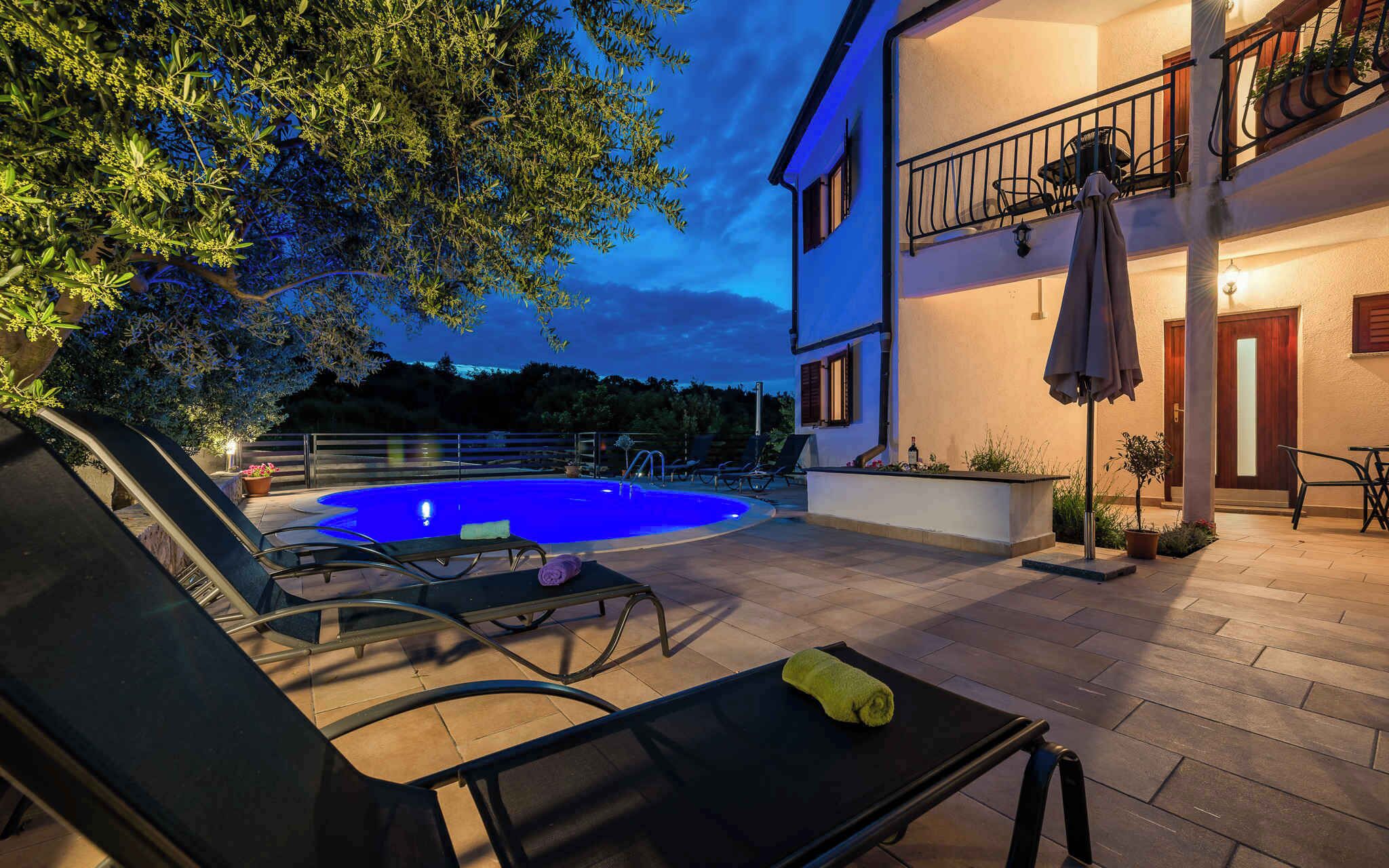 A poolside area with lounge chairs and a swimming pool, surrounded by a building with a balcony.