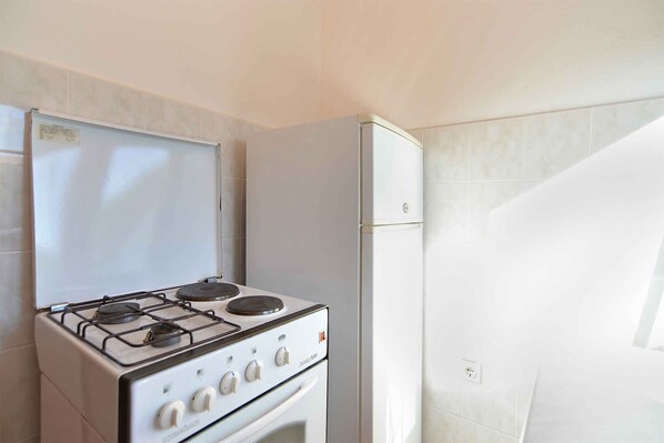 A kitchen with a stove, oven, and refrigerator.