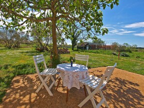 Relax in a serene outdoor setting surrounded by lush greenery and a rustic backdrop.