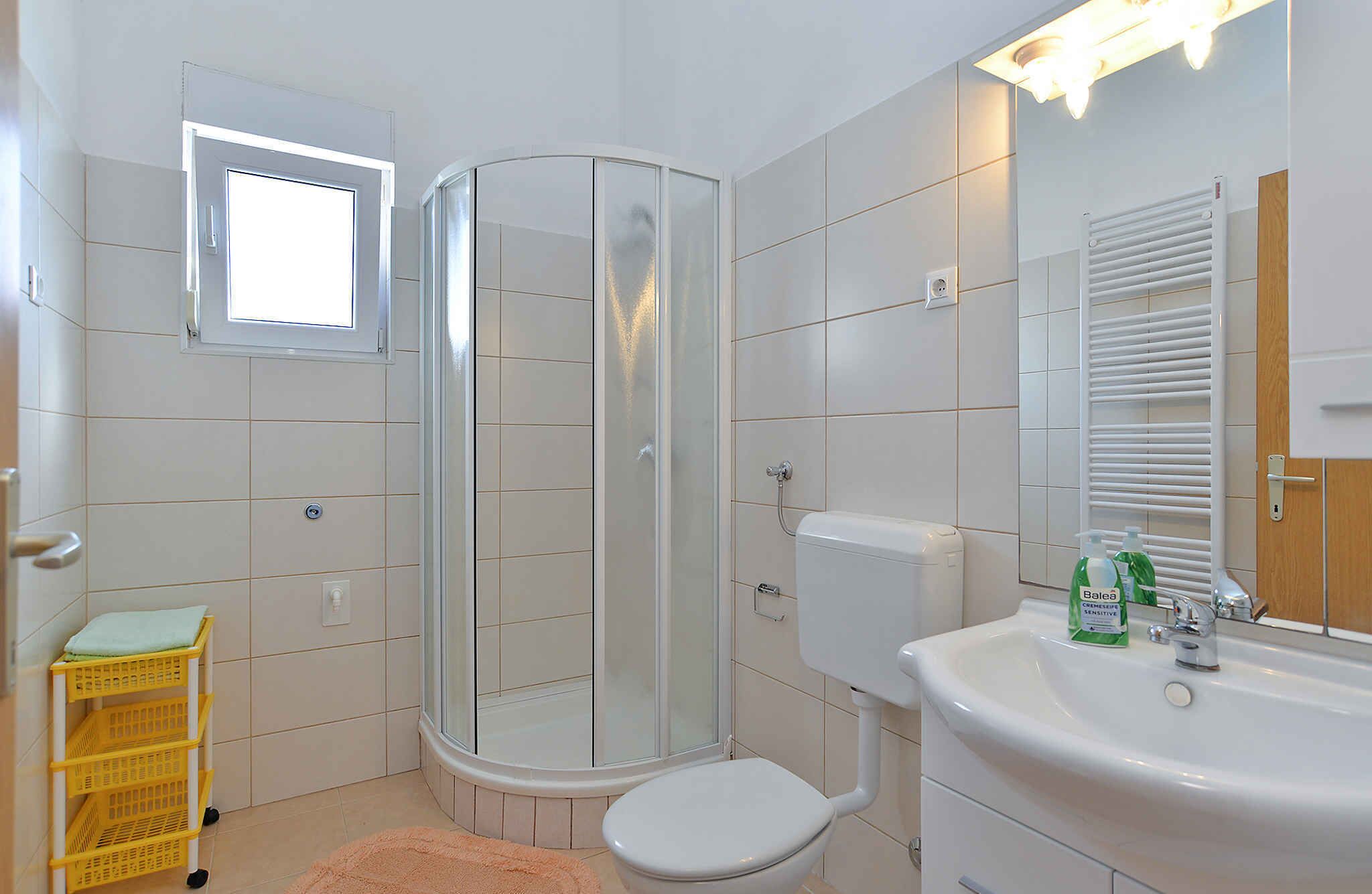 A bathroom with a shower, toilet, and sink.