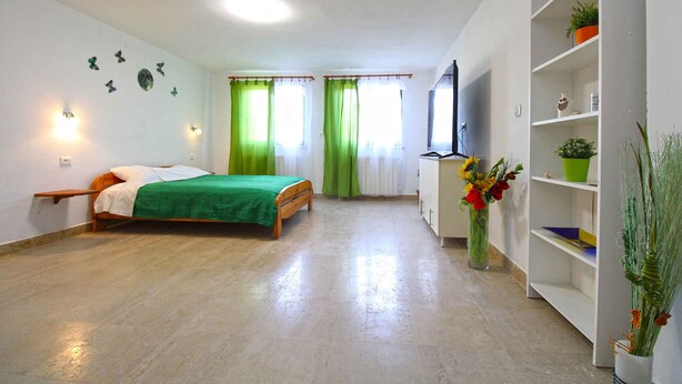 A bedroom with a bed, a wardrobe, a desk, and a window with curtains. - Holiday apartment with balcony (Valbandon)