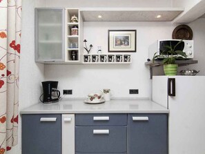 A compact kitchen with a microwave, a coffee maker, and a potted plant. - Holiday apartment with air conditioning (Valbandon)
