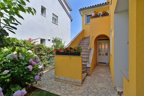 Stunning Mediterranean-style home with a charming garden entrance and paved patio.