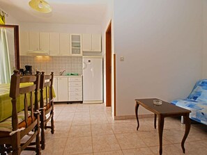 Un espacio habitable compacto con comedor, kitchenette y sofá.