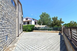 Stroll along the paved walkway to the building with a flat roof and balcony.