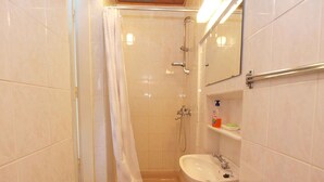 A bathroom with a shower, a sink, and a mirror. - Holiday apartment with terrace (Štinjan)