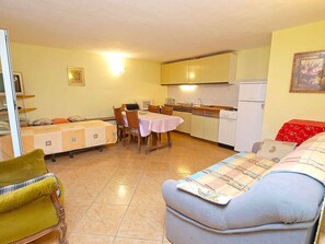 A compact living space with a kitchenette, a dining area, and a sofa.