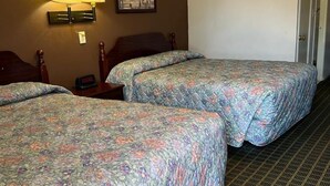A hotel room with two beds, a nightstand, a lamp, and a framed picture on the wall. - Aaron Motel (Portland)