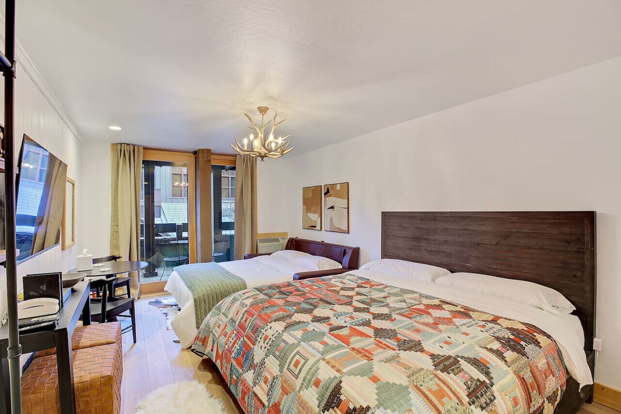 Une chambre d’hôtel avec un grand lit, un bureau et une vue sur la ville.