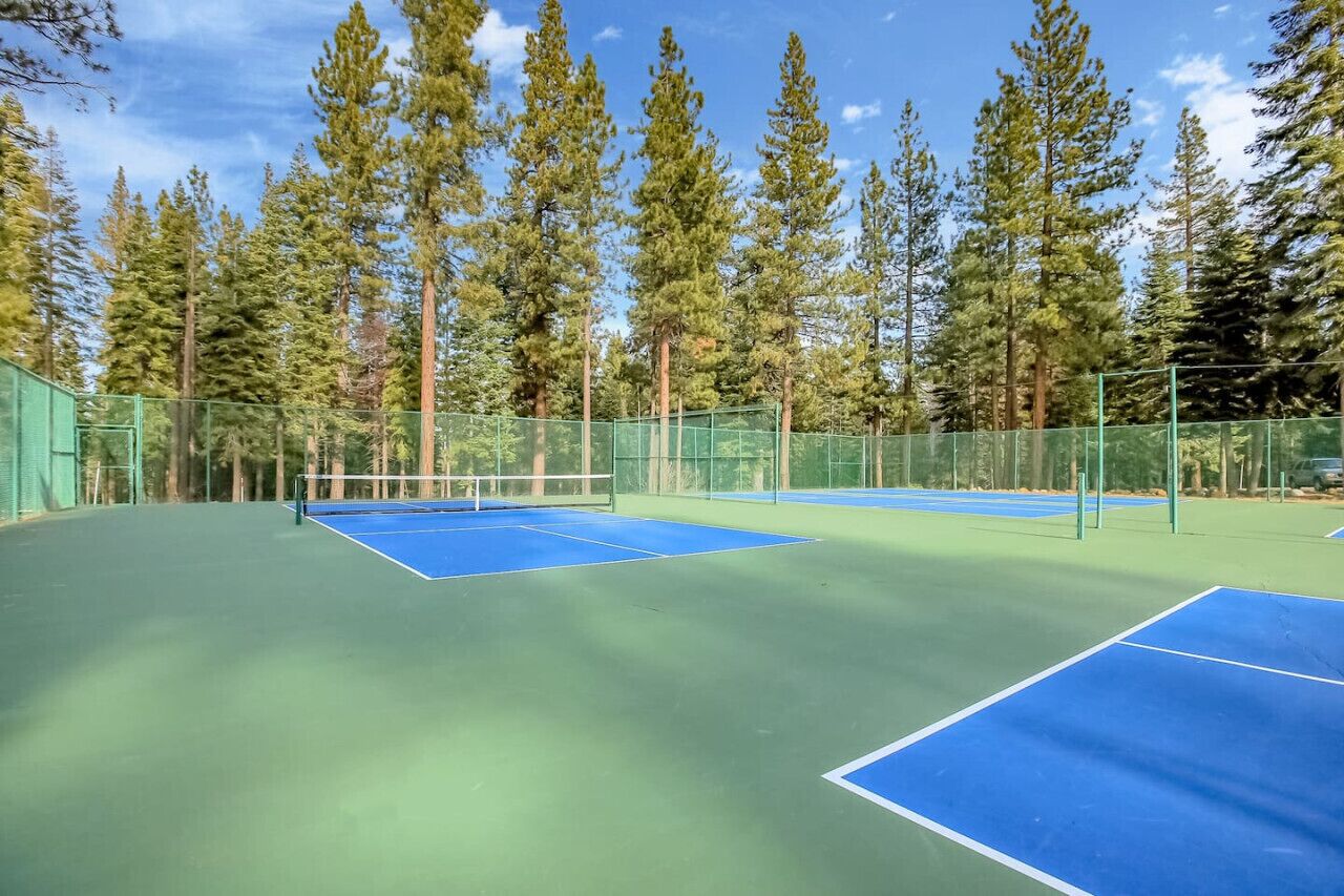 Un court de tennis en plein air, entouré de grands arbres.