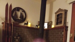 Una sala de estar acogedora con chimenea, una silla de madera y una revista sobre la mesa.
