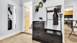 A modern interior with a black dresser, a mirror, and wall-mounted plants.
