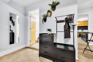A modern interior with a black dresser, a mirror, and wall-mounted plants.