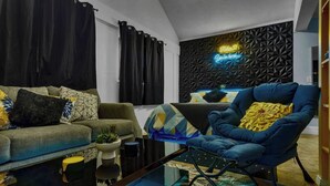 A modern living room with a sofa, armchair, coffee table, and decorative pillows.