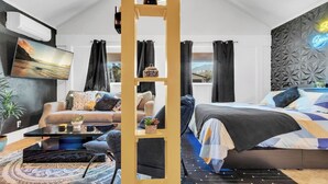 A modern bedroom with a bed, sofa, and a decorative wooden structure.