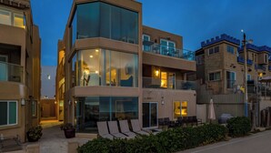 A multi-story hotel with a modern design, large windows, and a balcony area.