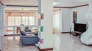 Un soggiorno moderno con un divano, una televisione e una mensola decorativa.