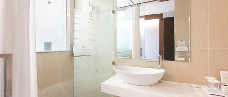 A modern bathroom with a glass shower enclosure, a white sink, and a large mirror.